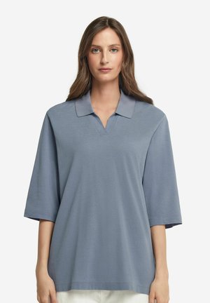 Lyseblå polo med v-hals, korte ærmer og glat tekstur, med et diskret mønster og et klassisk kravedesign.