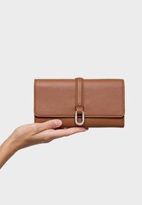 Brown leather wallet with a textured finish, featuring a silver hardware clasp and a front flap secured by a leather strap.