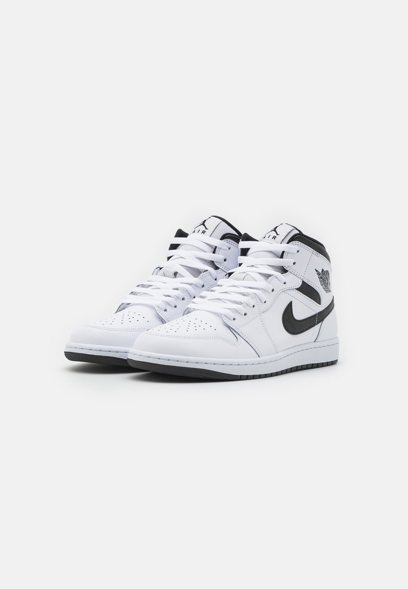 Zapatillas altas blancas con un logo de swoosh negro, caja de dedos perforada y cordones blancos. Diseñadas con un exterior de cuero suave y suela de goma.