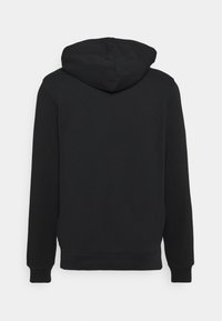 Hoodie noir à manches longues avec poches avant et capuche, vu de dos sur un fond clair uni.