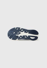 Semelle de chaussure en caoutchouc texturé bleu marine, avec un motif en vagues distinctif et une semelle intermédiaire blanche pour l'amorti.
