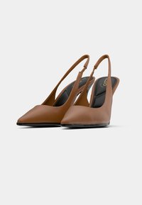 Escarpins slingback marron avec un bout pointu, en cuir lisse, au design élégant et minimaliste. Semelle intérieure noire coussinée visible.