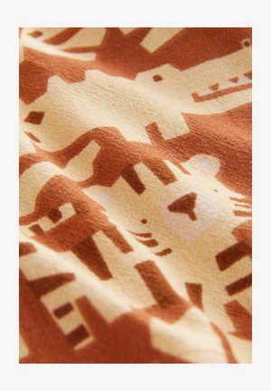 Texturált felületű pamutanyag, ismétlődő barna és krémszínű állatmintával, főként stilizált oroszlánokat ábrázolva.