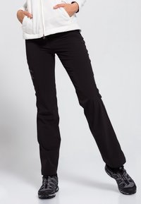 Svarta utomhusbyxor i lätt och elastisk textil, med en smal passform och en lätt utsvängning vid bensluten. Minimalistisk design utan synliga mönster.