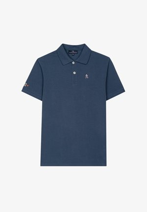 Camiseta polo azul marino de manga corta con dos botones blancos, un pequeño logo de palos de golf cruzados en rosa en el pecho y una parche en la manga izquierda.