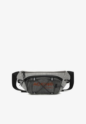 Borsa in tessuto grigio con tasca frontale in rete, dettagli neri, tracolla regolabile e brand arancione. Due cerniere nella sezione principale.