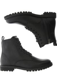 Botas de cuero negras hasta el tobillo con cordones en la parte delantera, cremallera lateral y suela de goma texturizada con un diseño de tacos para mayor tracción.