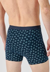 Boxer briefs blu navy realizzati in tessuto morbido, con un motivo ripetitivo di foglie di palma azzurro chiaro e una vita uniforme.