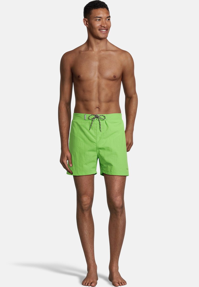 Shorts de bain verts vifs en matériau léger avec une taille à cordon de serrage et des poches latérales. Texture lisse, design à longueur de genou.