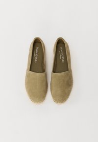 Zapatos sin cordones de ante verde oliva con suela de goma y ribete de yute cosido. El interior presenta una plantilla de tela con el nombre de la marca impreso.