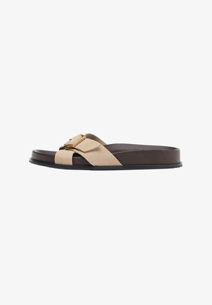 Sandalo marrone con ampia fascia in suede beige e fibbia color oro, suola piatta, punta aperta, vista laterale su sfondo bianco.