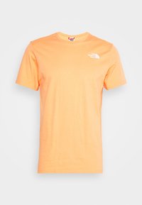 Pomarańczowa bawełniana koszulka z krótkim rękawem i okrągłym dekoltem. Posiada białe logo na klatce piersiowej oraz gładką fakturę.