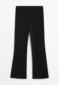 Pantaloni neri da donna sartoriali con leggero svaso, due tasche a filetto posteriori e cintura piatta, distesi su uno sfondo bianco.