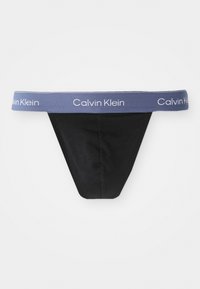 Schwarze Stringunterwäsche mit einem weichen, elastischen blauen Bund, der mit weißen "Calvin Klein"-Marken versehen ist. Klassisches Design mit minimalistischer Form.