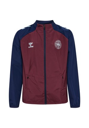 Vinrød og marineblå sportjakke med fuld lynlås foran, to sidelommer, Hummel-logo på venstre bryst og Dansk Boldspil Union-emblem på højre bryst.