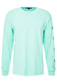 Vaaleanmintunvihreä pitkähihaisuus t-paita, joka on valmistettu pehmeästä materiaalista. Siinä on pyöreä kaulus ja painettua tekstiä sinisenä hihojen varrella.