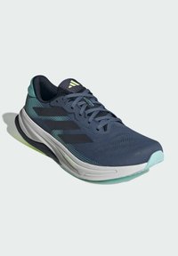 Scarpa da corsa con tomaia in rete blu navy, dettagli verde chiaro e strisce nere. Presenta una suola ammortizzata e un motivo testurizzato sul tessuto.