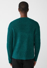 Tekstuuriga roheline kudumine särk, millel on mugav lõige, langenud õlad ja soonikkoes mansetid. Helkuril on külgmised lõhikud, et tagada liikumisvabadus.