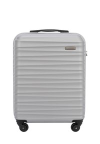 Silver hard-shell suitcase with a ribbed design, a top handle, four wheels, and a small logo on the front. Smooth texture.