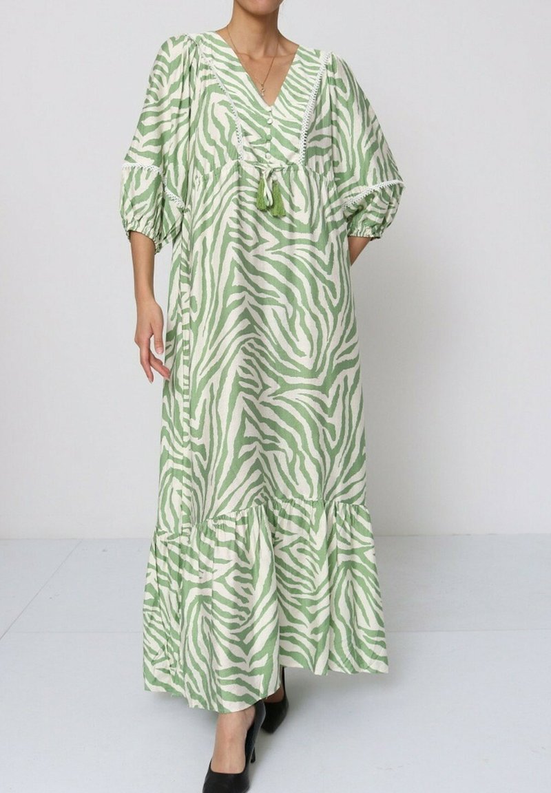 Robe maxi rayée verte et blanche avec un décolleté en V, des manches bouffantes et un ourlet à volants. Fabriquée en tissu léger avec un design décontracté.