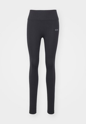 Leggings de sport noirs avec une texture lisse, une taille haute et des détails cousus. Présente un petit logo à l'avant.