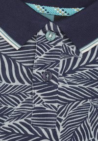 Marineblauwe polo met een bladerenpatroon, gemaakt van een gestructureerde stof, met een geribbelde kraag en blauwe knopen. Bevat een decoratieve geweven accenten op de kraag.