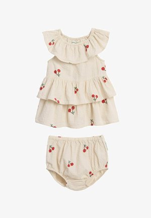 Beige babyjurk en bijpassende broekjes met rode kersenprints, met geplooide kraag en gelaagde rok.
