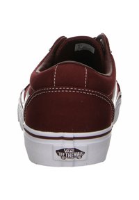 Maroon canvas sneakers with a white rubber sole, featuring stitching details and the Vans logo on the heel. Classic design and low-top style.