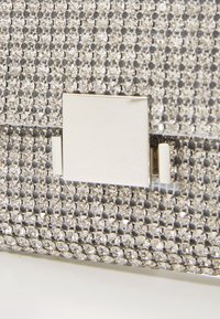 Rhinestone kuvertväska med ett silverfärgat rektangulärt spänne; har en texturerad yta prydd med flera klara kristaller.