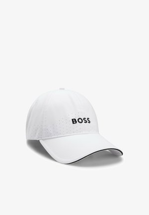 Biała czapka z daszkiem bejsbolowym z perforowanymi bokami i logo „BOSS” w czarnych literach z przodu, z zakrzywionym daszkiem z czarnym obszyciem.