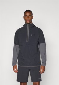 Čierny a šedý ľahký vetrovka s dizajnom na polovičný zips, elastickými manžetami a logom na hrudi, doplnená o zodpovedajúce šortky.