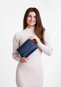 Námořnická kožená kabelka s hladkým povrchem, s klopovým zapínáním a embosovaným logem. Jednoduchý design, obdélníkový tvar, vhodná pro různé příležitosti.