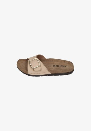 Beige slide sandal with a wide strap, rectangular silver buckle, and cork footbed. Textured sole for grip and comfort.