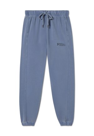 Jogging en bleu clair fabriqué en tissu doux, avec une taille élastique munie d'un cordon de serrage, des poches latérales et un petit logo imprimé près de la taille.
