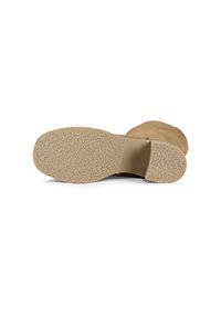Light brown suede boot lying on its side showing textured rubber sole and low block heel on white background.
