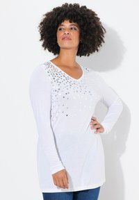 Witte langemouwen V-hals t-shirt met een zilveren sterrenpatroon op de bovenste linkerzijde, gemaakt van zachte stof, met een relaxte pasvorm.