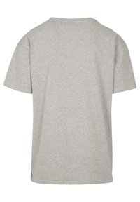 Camiseta gris de cuello redondo hecha de algodón. Mangas cortas, corte relajado y una textura suave sin logotipos ni patrones visibles. Se muestra la vista posterior.