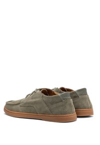 Sive suede cipele s niskim profilom, prošivene detalje, kožne akcenti i gumeni đon. Dizajn sa vezanjem i blagim podizanjem pete.