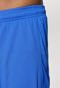 Blå atletiske shorts lavet af åndbart stof, med elastisk talje, glat overflade og sidelommer for ekstra funktionalitet.
