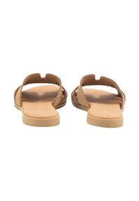 Sandalias planas marrones con los dedos y el talón al aire. Fabricadas en material suave, con un diseño minimalista y correas flexibles. Suela suave en tono marrón claro.