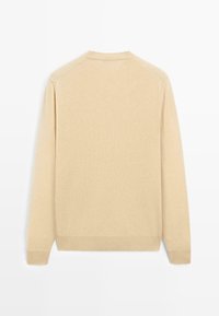 Béžový pletený svetr s dlouhými rukávy, kulatým výstřihem a žebrovanými manžetami. Hladká textura bez viditelných vzorů či kovových detailů.