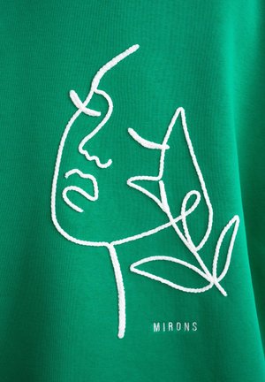 Tissu vert présentant un dessin en ligne brodé blanc d'un visage et d'une feuille, avec le texte "MIRONS" en bas. Texture lisse avec un subtil éclat.