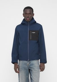 Marineblå jakke med hætte, der har en sort brystlomme, lynlåslukning og et rent design. Fremstillet af holdbart materiale.