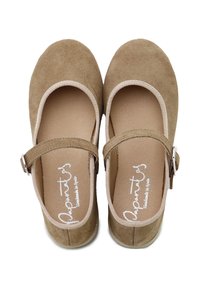 Zapatos Mary Jane de gamuza beige con punta redondeada, correas en el tobillo y hebillas plateadas, vistos desde arriba sobre un fondo blanco.