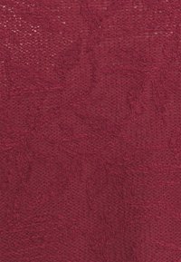 Burgundské pletené tkaniny s texturovaným květinovým vzorem, který obsahuje složité designy listů a měkkou, mírně otevřenou vazbu.
