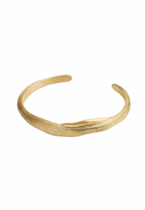 Pulsera de brazalete en tono dorado con un diseño texturizado y ondulado. Presenta bordes lisos y sutiles estrías para mayor interés visual. Metal ligero.
