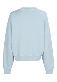 Jasnoniebieska, krótkia bluza z okrągłym dekoltem, opuszczonymi ramionami i ściągaczami na rękawach. Gładka faktura, casualowy design, bez zdobień.