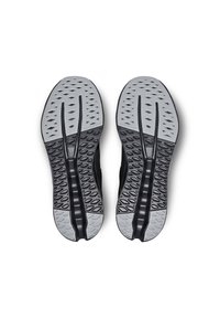 Schwarze Sportschuhe mit einer strukturierten grauen Sohle. Die Sohle zeigt diamant- und ovalförmige Muster für Grip und Flexibilität.