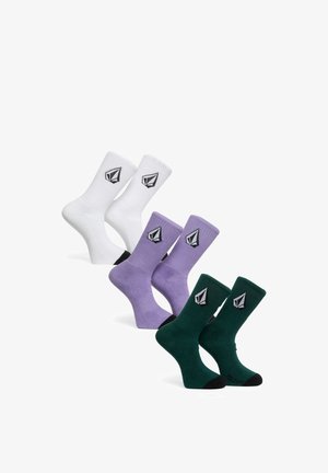 Three pairs of crew socks in white, purple, and dark green, each with a black and white geometric logo on the calf area.