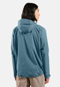 Veste imperméable dans une teinte bleu-vert discrète, avec une capuche, des poignets élastiques et un ourlet avec un cordon de serrage ajustable. Texture lisse.